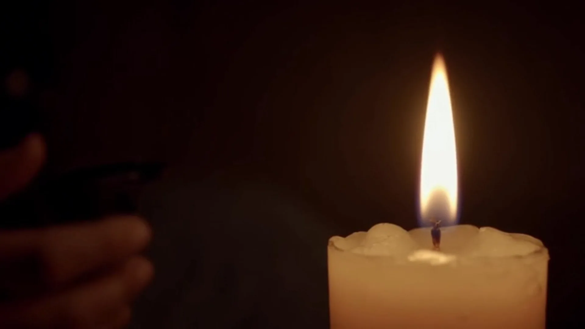 Vela acesa em um ambiente escuro, símbolo de esperança em meio à ansiedade