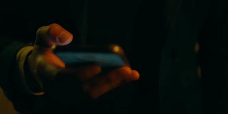 Mãos segurando um celular, digitando uma mensagem